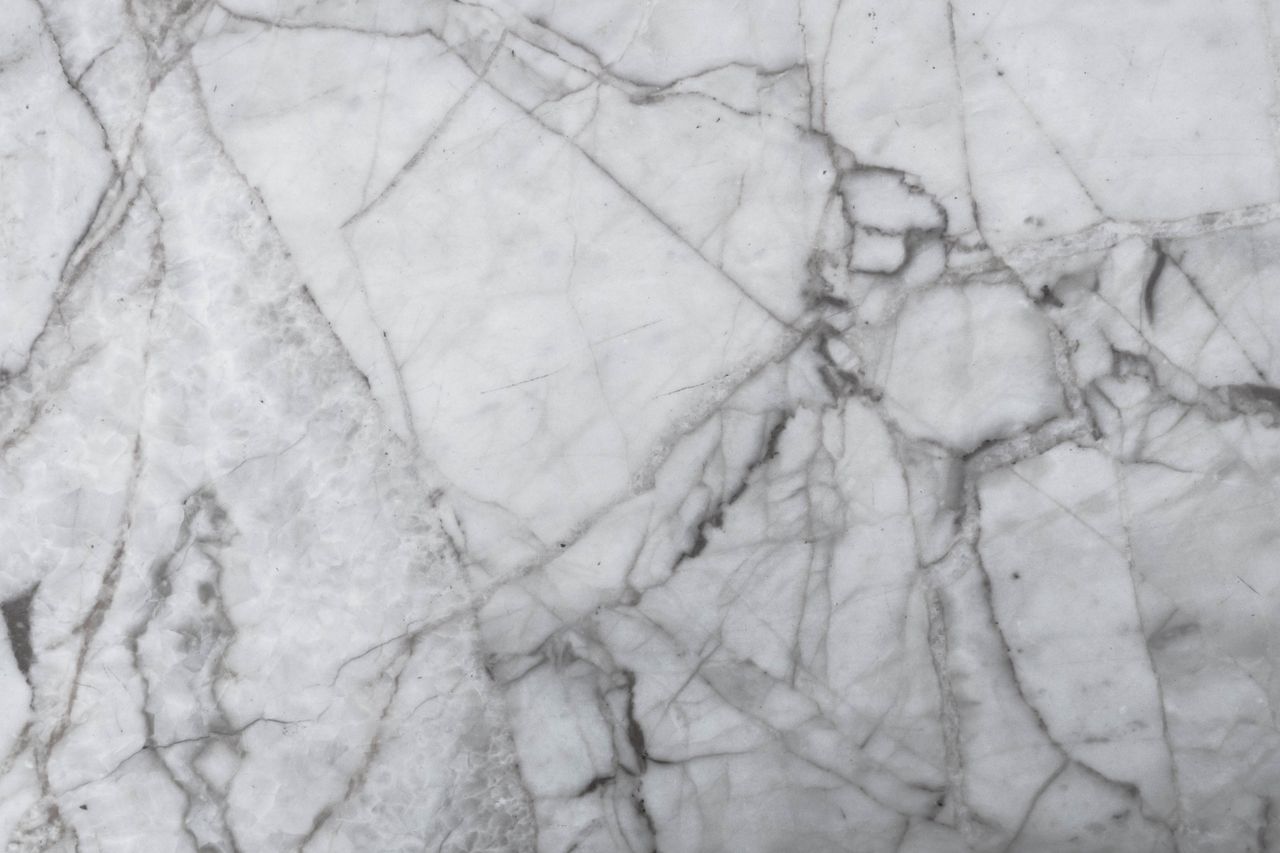 High-resolution image of textured marble surface with natural patterns, perfect for design and architecture uses.